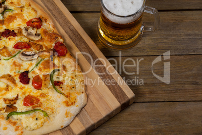 Delicious pizza served on pizza tray with a glass of beer