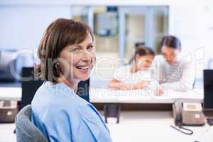 Portrait of smiling nurse sitting at desk