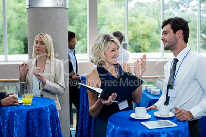 Business executives interacting with each other while having coffee