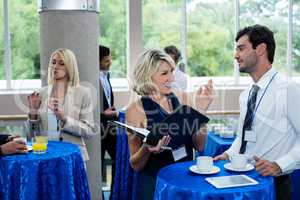 Business executives interacting with each other while having coffee