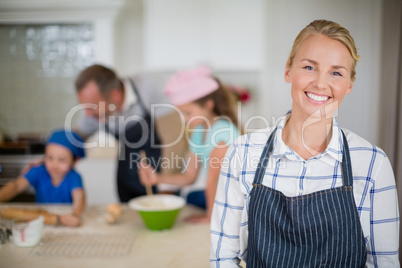 Smiling woman in apron standing at kitchen