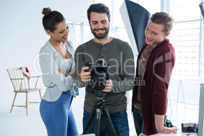 Photographers and model reviewing captured photos in his digital camera