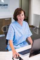 Portrait of smiling nurse working at desk