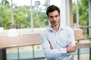 Male business executive with arms crossed at conference center