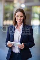 Cheerful businesswoman holding a digital tablet