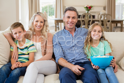 Parents and kids watching tv in living room