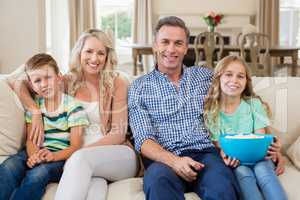 Parents and kids watching tv in living room