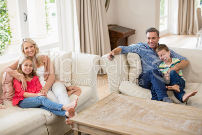 Parents and kids watching tv in living room