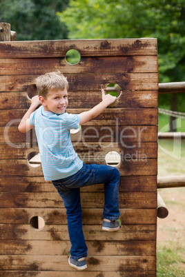 Boy climbing on a playground ride in park