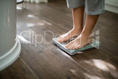 Boy checking his weight on weight scale