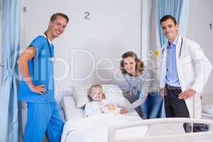 Portrait of doctors, patient and woman in hospital room