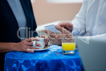 Mid section of business executives interacting with each other during break