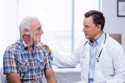 Doctor consoling senior man