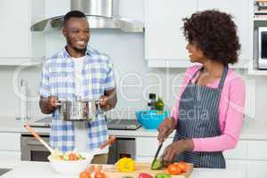 Smiling couple chopping vegetables in the kitchen