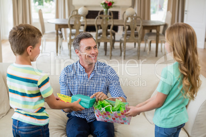 Kids giving surprised gift to their father