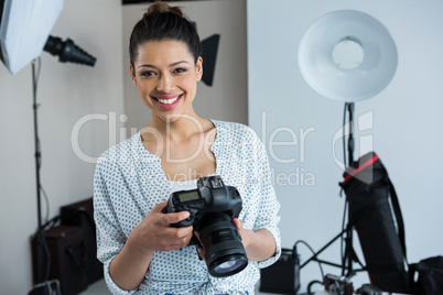 Happy female photographer standing in studio