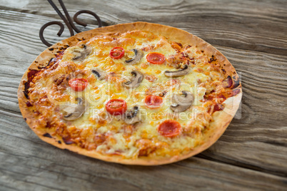Italian pizza served in a pan on a wooden plank