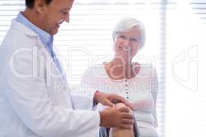 Physiotherapist giving knee therapy to senior woman