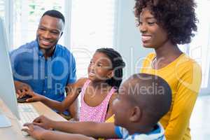 Happy family using computer in living room