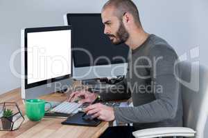 Male photographer using graphic tablet at desk