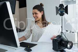 Female photographer working over computer at desk