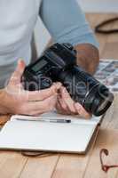 Male photographer reviewing captured photos in his digital camera