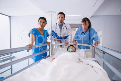Doctors examining patient in corridor