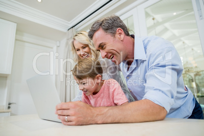 Parents and son using laptop at home