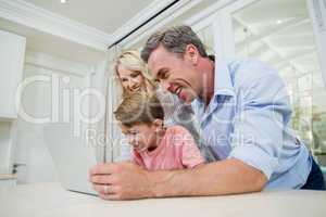 Parents and son using laptop at home