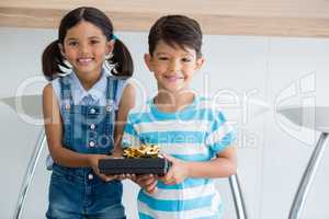 Portrait of siblings holding gift box