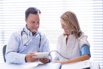 Doctor checking blood pressure of a patient in clinic