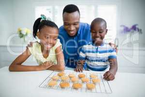 Father and kids looking at cookies on table
