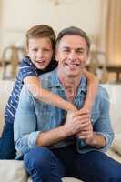 Smiling son embracing a father in living room