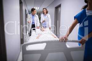 Doctors pushing emergency stretcher bed in corridor