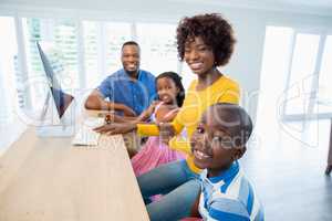 Happy family using computer in living room at home