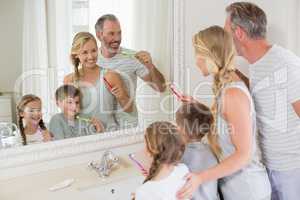 Parents and kids brushing teeth in bathroom
