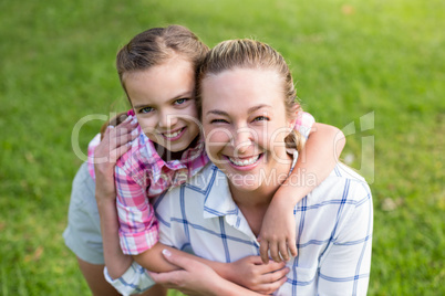 Mother holding hands of her daughter in park