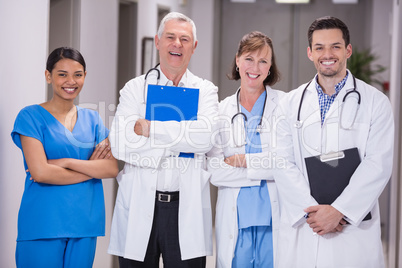 Portrait of smiling doctors and nurse standing with arms crossed