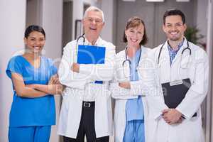 Portrait of smiling doctors and nurse standing with arms crossed