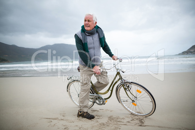 Senior man riding bicycle on the beach