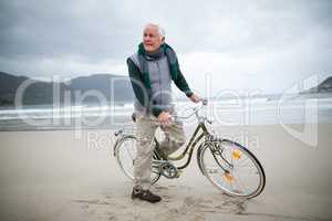 Senior man riding bicycle on the beach