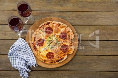 Italian pizza served in a pizza tray with red wine