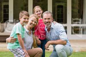 Happy family with arm around sitting in garden