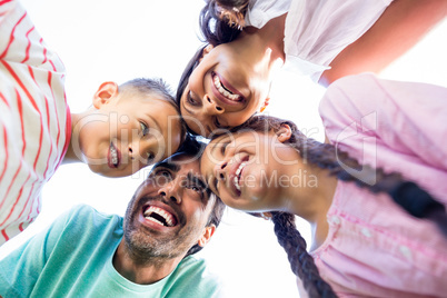 Happy family forming huddle in park