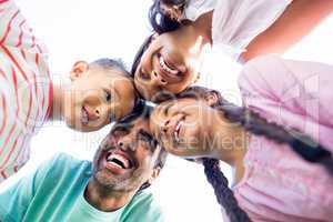 Happy family forming huddle in park