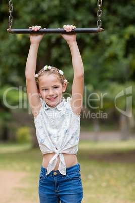 Girl hanging on a playing equipment in park