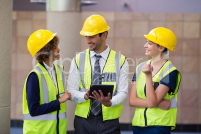 Architects discussing over digital tablet