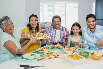 Happy multi generation family having meal on table at home