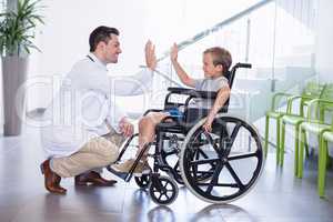 Doctor giving high five to disable boy