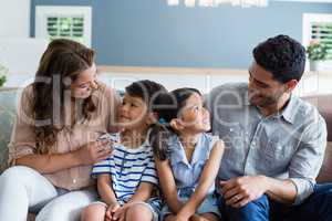 Parents and kids interacting on sofa in living room